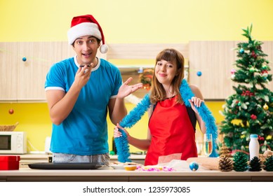 Young Couple Celebrating Christmas In Kitchen 