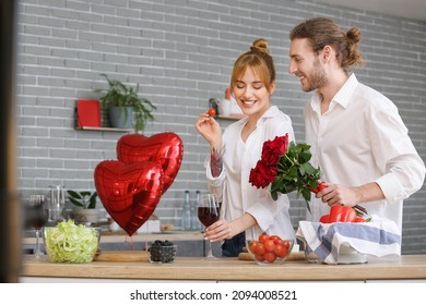 Young couple celebrating Valentine's Day while cooking festive dinner at home - Shutterstock ID 2094008521