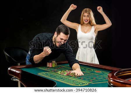 Young couple celebrating win at roulette table in casino. 
