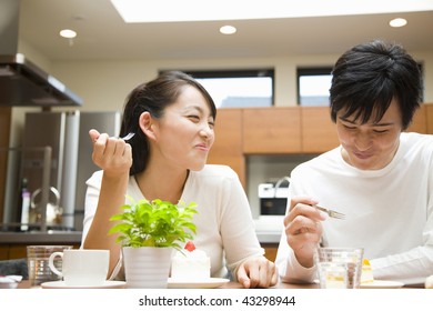 A young couple chatting and eating in the kitchen