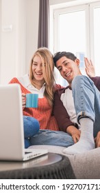 Young Couple Chatting With Friends Or Family On A Video Call With Their Laptop While Staying At Home.