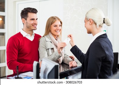 Young Couple Check In At Hotel Reception