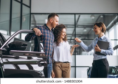 Young Couple Choosing A Car In A Car Show Room