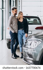 Young Couple Choosing A Car In A Car Show Room