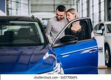 Young Couple Choosing A Car In A Car Show Room