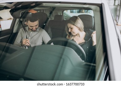 Young Couple Choosing A Car In A Car Show Room