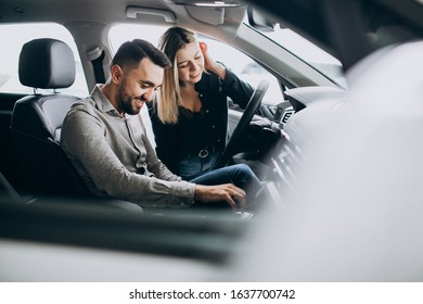 Young Couple Choosing A Car In A Car Show Room