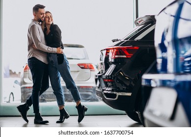 Young Couple Choosing A Car In A Car Show Room