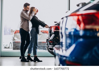 Young Couple Choosing A Car In A Car Show Room