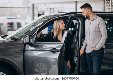 Young Couple Choosing A Car In A Car Show Room