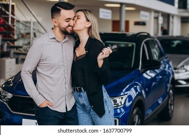 Young Couple Choosing A Car In A Car Show Room