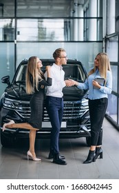 Young Couple Choosing A Car In A Car Show Room