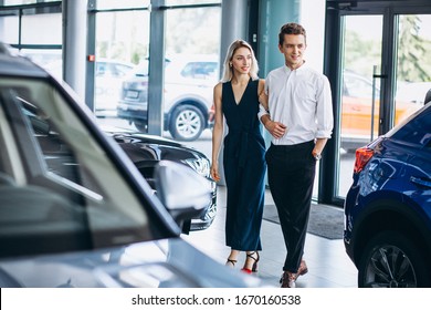 Young Couple Choosing A Car In A Car Show Room