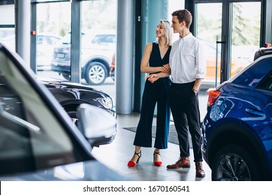 Young Couple Choosing A Car In A Car Show Room