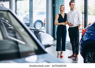 Young Couple Choosing A Car In A Car Show Room