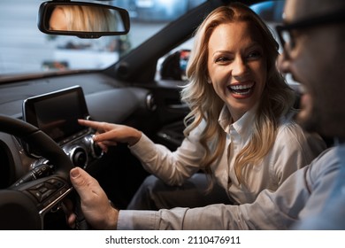 Young couple choosing a car in a car show room. Portrait of blonde hair woman with beautiful smile. - Shutterstock ID 2110476911