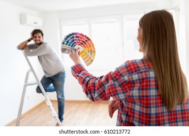 Young Couple Choosing Color For Painting Home