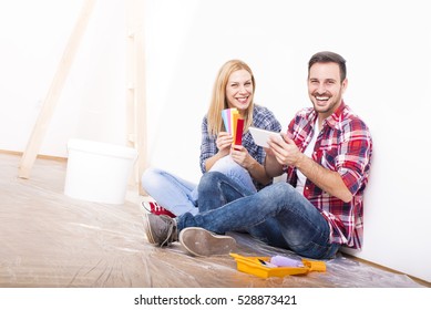 Young Couple Choosing Color Palette And Furniture At Home Together. Home, Moving, Decoration, Renovation, And Wall Painting Concept