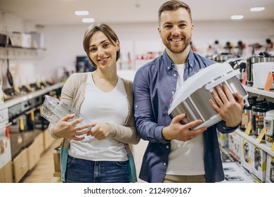 Young Couple Choosing Crockpot At Electric Store