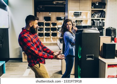 Young couple choosing music speaker for their home in an electronics store. - Shutterstock ID 1531973918