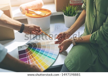 young couple choosing paint colur from swatch for new home interior
