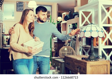 Young couple choosing table lamp for apartment in furnishings store - Shutterstock ID 1126668713