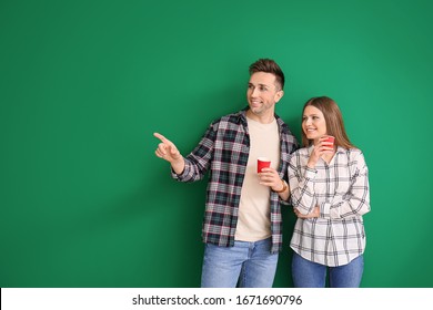 Young Couple With Coffee On Color Background