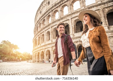 Young Couple At The Colosseum, Rome - Happy Tourists Visiting Italian Famous Landmarks