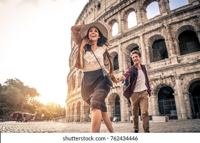 Young couple at the Colosseum, Rome - Happy tourists visiting italian famous landmarks