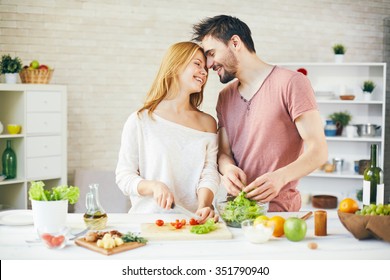 Young Couple Cooking Fresh Vegetarian Salad Together