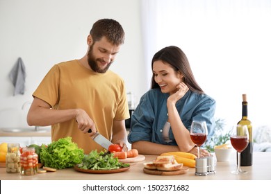 Young Couple Cooking Together In Kitchen