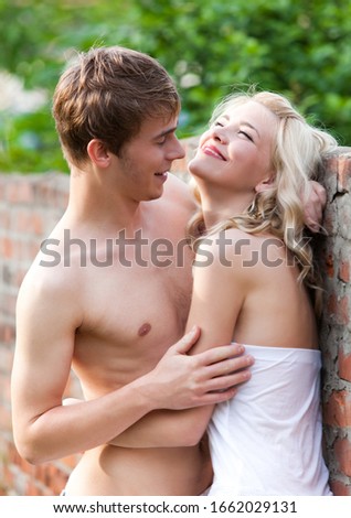 Young couple cuddling while walking on a sunny sunny summer day bridge. Concept of love and romance and fidelity