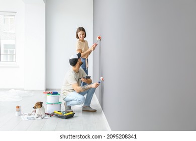 Young Couple With Cute Dog Painting Wall In Their New House