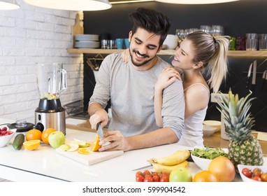 Young couple cutting fruit in the kitchen  - Powered by Shutterstock