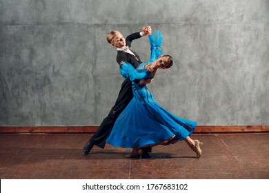 Young couple dance slow waltz in ballroom