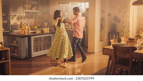 Young Couple Dancing and Having Fun in the Kitchen: Enjoying Each Other's Company and Playfully Moving to Music. With Joyful Laughter and Smiles, they Embrace the Music and Dance - Powered by Shutterstock