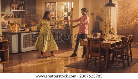 Young Couple Dancing and Having Fun in the Kitchen. Boyfriend and Girlfriend Sharing Moment of Love and Tenderness. With Joyful Laughter and Smiles, they Embrace the Music and Dance.