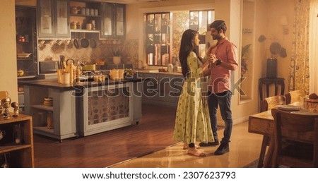 Young Couple Dancing and Having Fun in the Kitchen. Boyfriend and Girlfriend Sharing Moment of Love and Tenderness. With Joyful Smiles, they Embrace the Music and Dance.