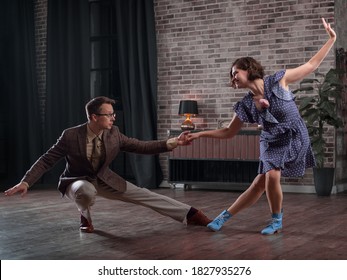 a young couple dancing swing in a stylish room in the evening