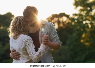 Young Couple Dancing Together Outside At Sunset