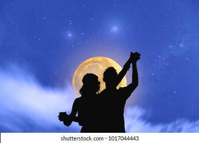 Young Couple Dancing Under The Moonlight And Stars. 