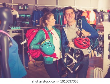 Young Couple Demonstrates The Selected Travel Gear In Sports Shop