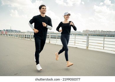 A young couple do sports, train outside, have a healthy lifestyle. Fitness watch on hand.