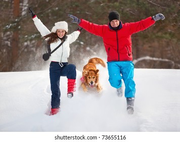 Young Couple With Dog Winter Outdoors Fun.