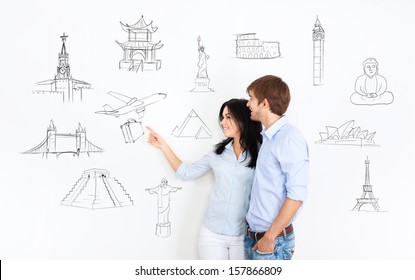 Young Couple Dream Think About Vacation, Holiday Trip, Man And Woman Planning Draws Travel Around The World On White Wall