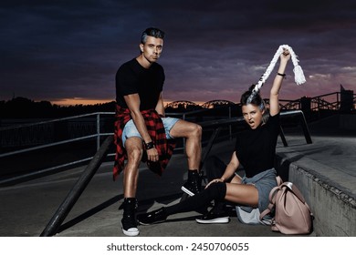 Young couple dressed in trendy urban-style clothes poses in a skatepark. - Powered by Shutterstock