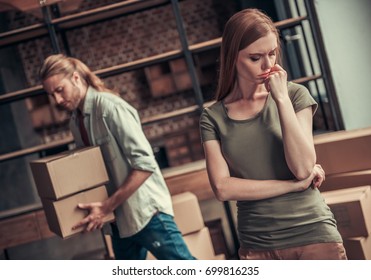 Young Couple Is Drifting Apart After Breakup, Man Is Carrying His Stuff In Cardboard Boxes