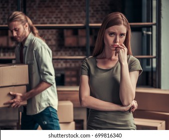 Young Couple Is Drifting Apart After Breakup, Man Is Carrying His Stuff In Cardboard Boxes