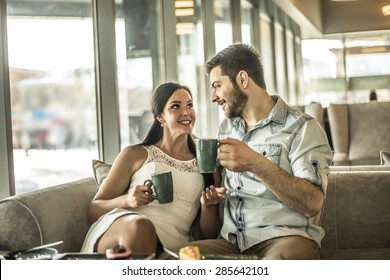 Young Couple Drink Coffee With Handsome Man Look In Eyes Each Other Girl Friend Woman Look At Cake Near Together Against Glass Window View In Perspective Happy Couple Enjoy Coffee At Coffee Shop Cafe 