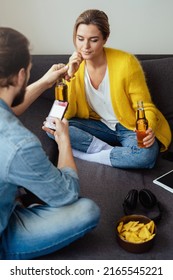 Young Couple Drinking Beer And Eating Nachos Chilling At Home